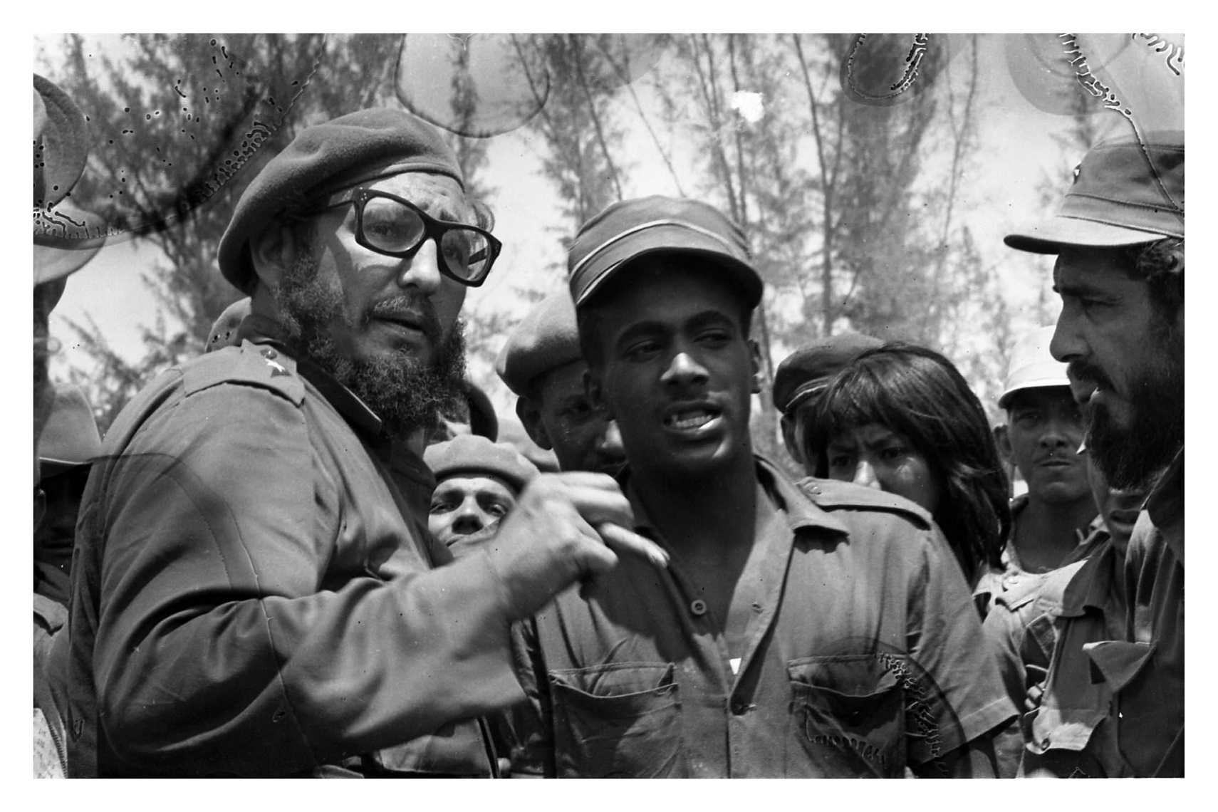 Grupo de milicianos y combatientes conversando en Playa Girón, fotografía histórica en blanco y negro