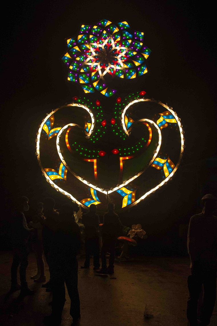 Gran farola iluminada de las parrandas con figuras de colores en la noche