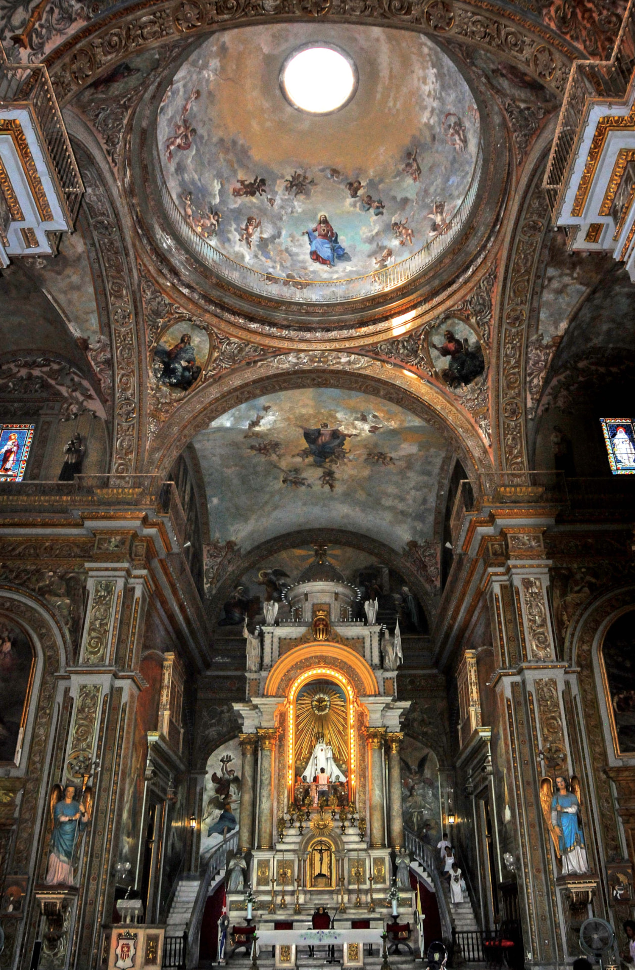 Interior de una iglesia cubana con cúpula pintada y altar dorado